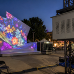 Climate controlled projector enclosure mounted on truss for a temporary event projection mapping setup.