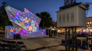Climate controlled projector enclosure mounted on truss for a temporary event projection mapping setup.