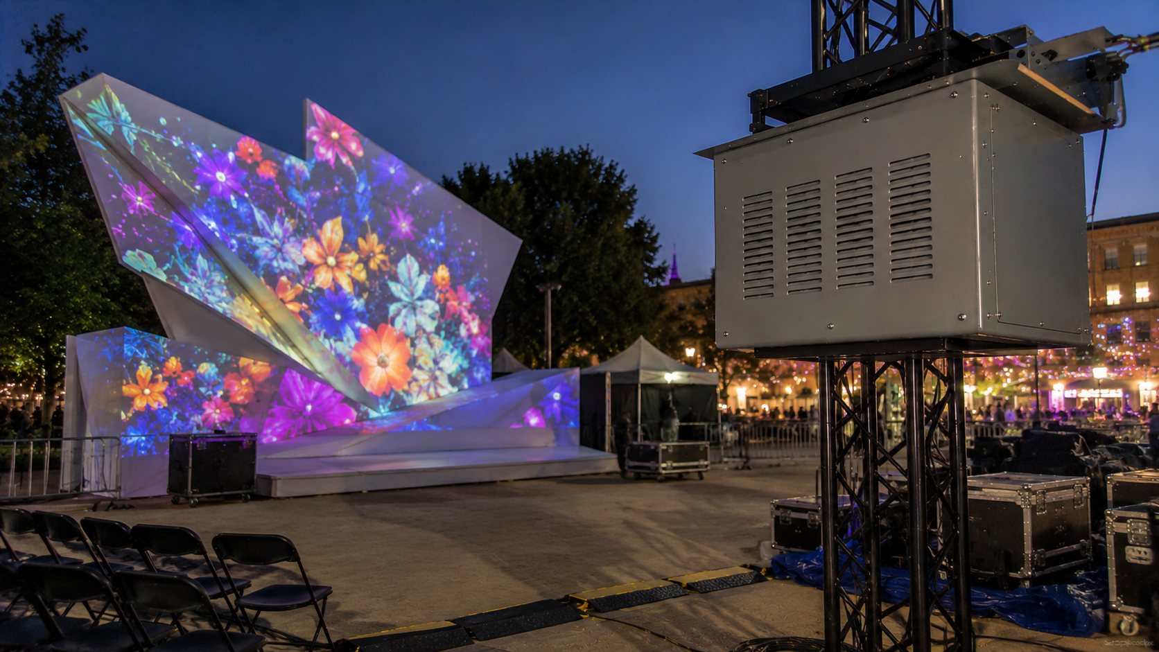 Climate controlled projector enclosure mounted on truss for a temporary event projection mapping setup.