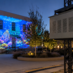 Climate controlled projector enclosure mounted on truss for an outdoor projection mapping installation.
