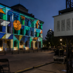 Climate controlled projector enclosure mounted on truss for building projection mapping on an outdoor facade.