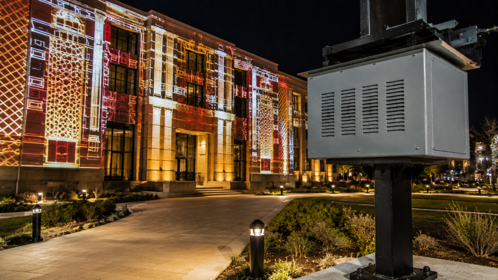 Climate controlled projector enclosure protecting a permanent outdoor projection mapping installation on a civic building.