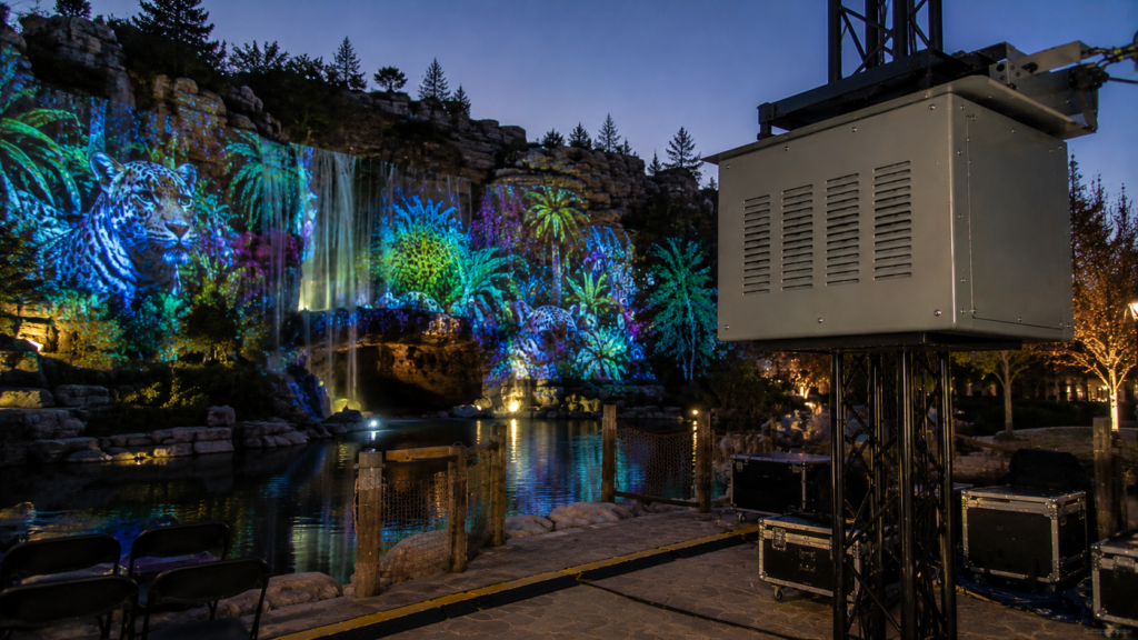 Climate controlled projector enclosure supporting landscape and rock projection mapping in an outdoor attraction.